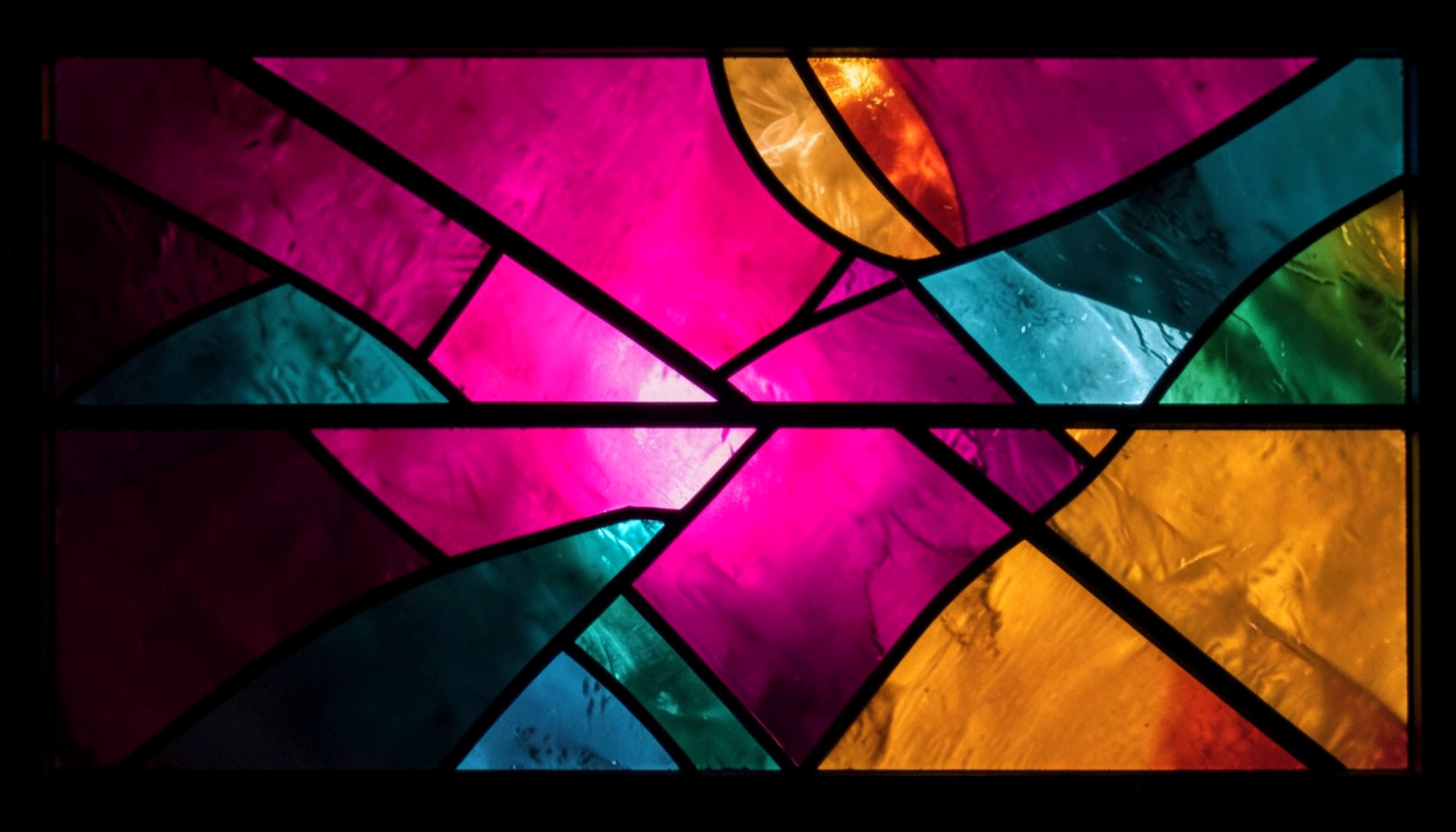 A stained-glass composition with bold leaded segments in deep magenta, teal, and amber, forming an abstract interplay of light and structure