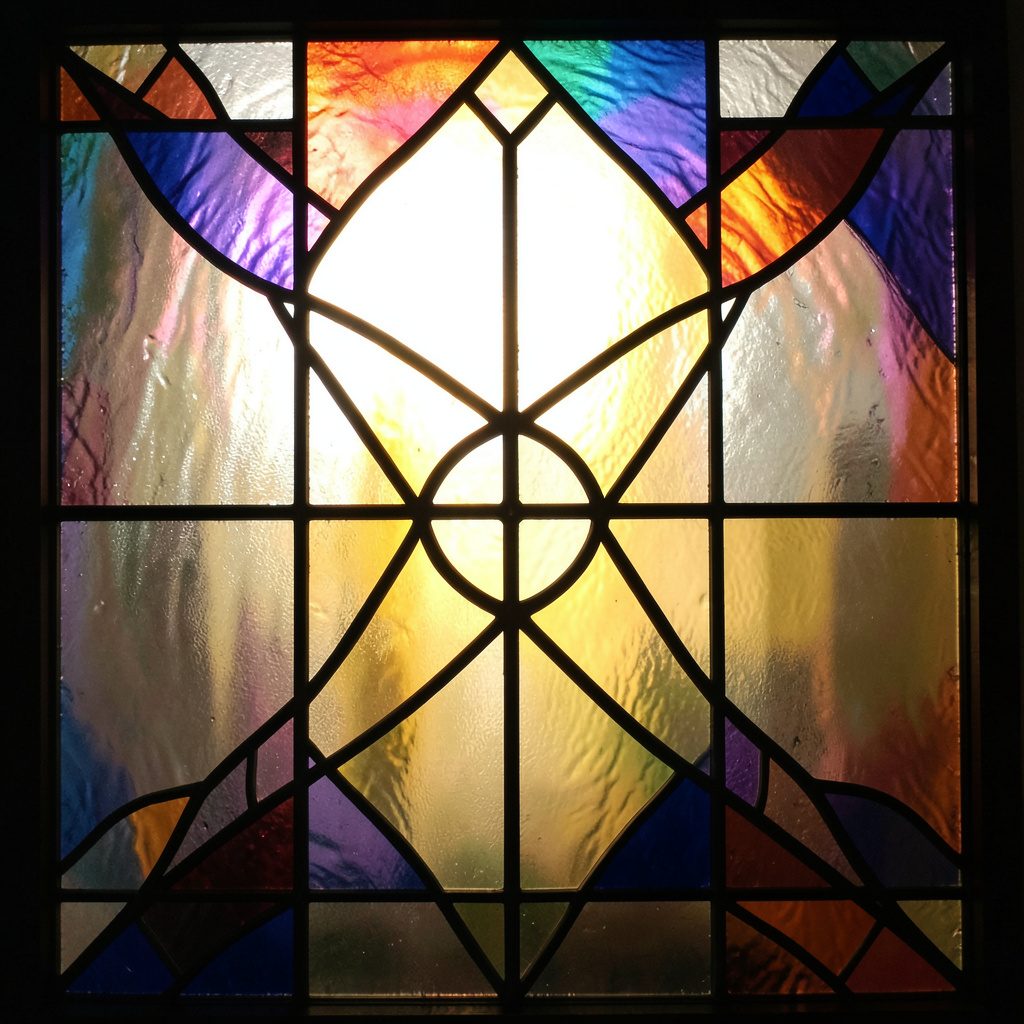 A stained-glass composition of layered mint and teal rectangles with thick black leading, a glowing gold accent stripe running diagonally, suggesting backup and safekeeping.