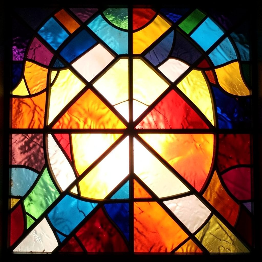 A wide stained-glass footer panel in deep teal and mint green with bold black leading, scattered coral and gold fragments forming a rhythmic, fan-like composition.